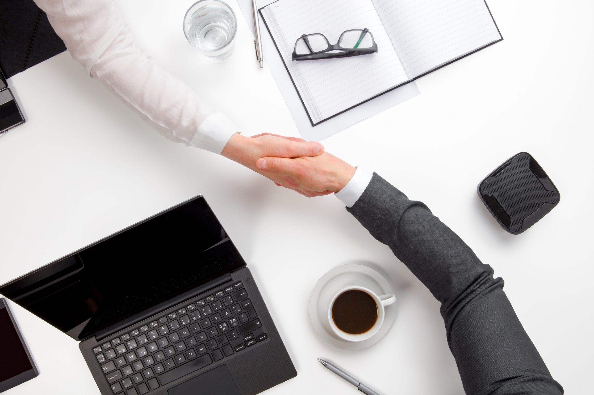 Business People Shaking Hands At Office Desk